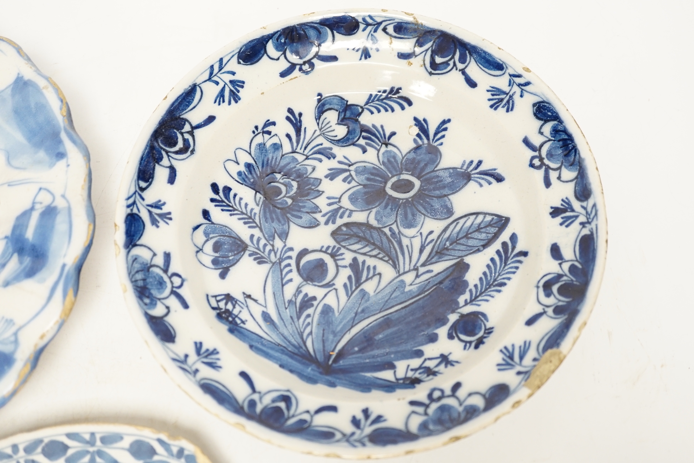 A Delft lobed blue and white dish, 1680-1700 and two 18th century Delft plates, largest 21cm in diameter